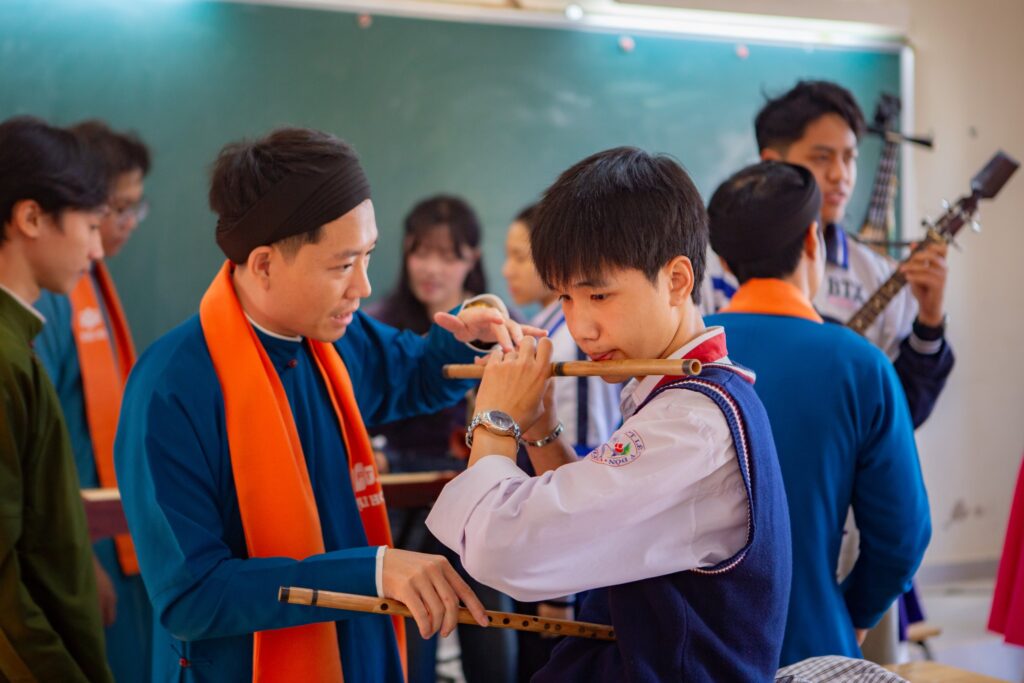 Học sinh trải nghiệm nhạc cụ dân tộc dưới sự hướng dẫn của các giảng viên FPTU